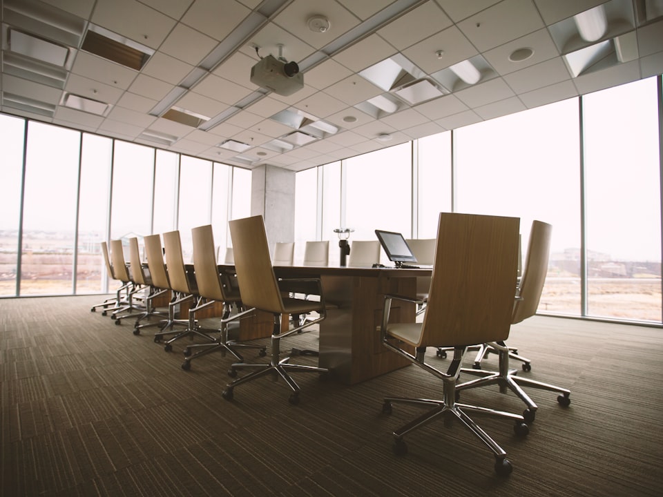An empty wooden conference table with chairs